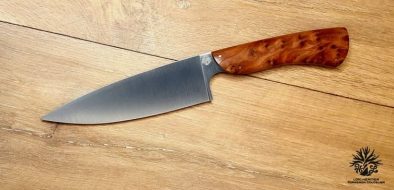 couteau de chef artisanal haut de gamme avec manche en bois du luberon . La lame est fabriquée en acier inoxydable robuste et finement affûtée, idéale pour une précision de coupe en cuisine. Le manche en bois de thuya présente des motifs de grain riches et une finition lisse avec des rivets en acier inoxydable, alliant esthétique traditionnelle et modernité. Cet outil de cuisine est à la fois fonctionnel et élégant, reflétant l'excellence de l'artisanat coutelier.